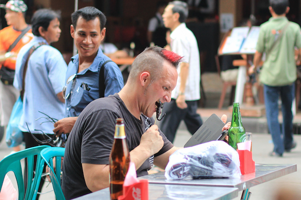 Tourist eating scorpion on Khao San Road
